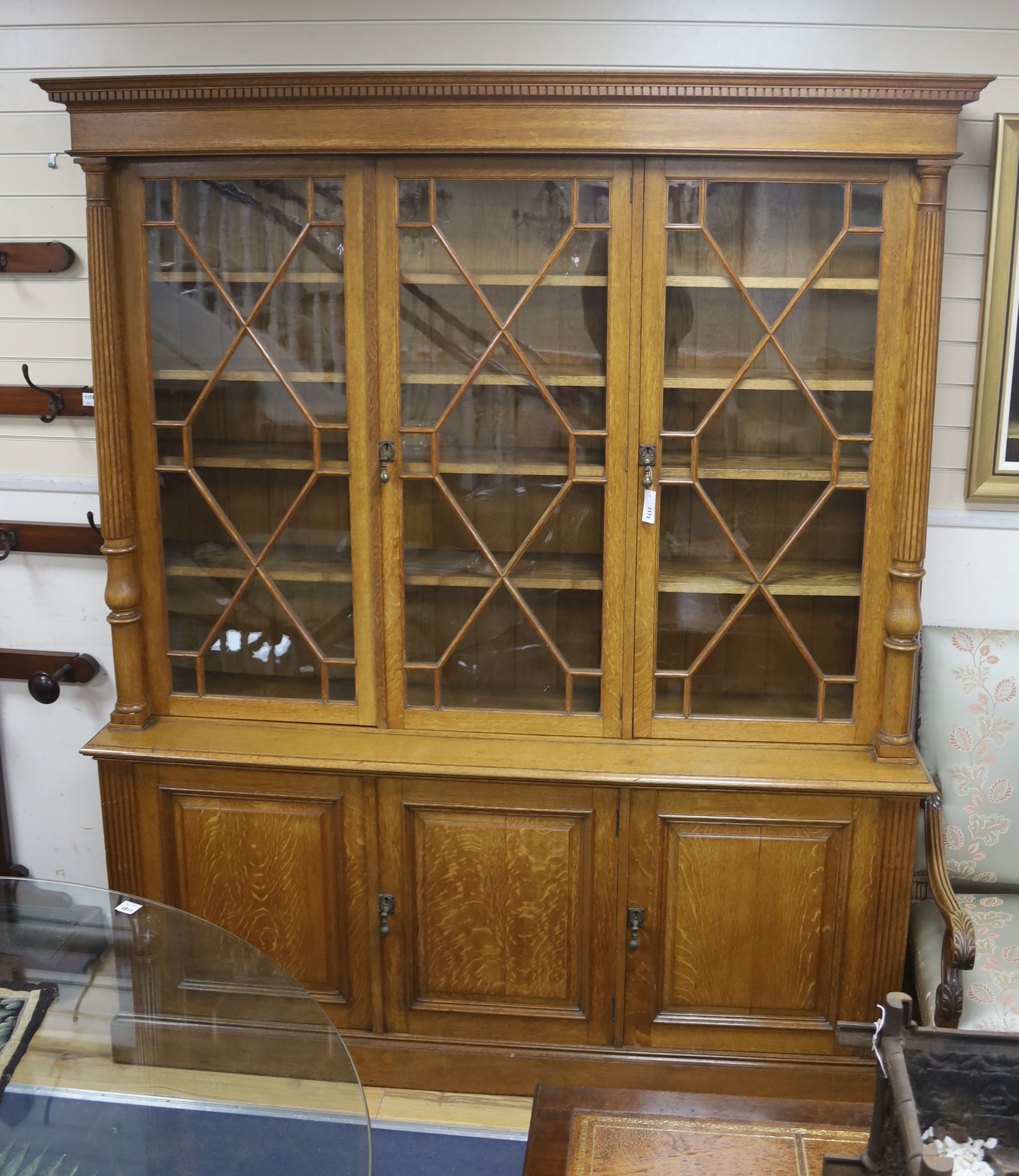 An Edwardian pale oak library bookcase by Robson and Sons of Newcastle, width 190cm, depth 45cm, height 228cm